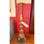 A C19th carved giltwood altar candlestick raised on a circular marble base