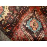A Persian hand knotted Qashgai carpet the rust coloured ground having quadruple diamond pendants and