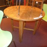 A Heals  style oak kitchen table the circular top raised on stretchered supports
