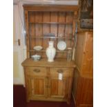 A Victorian pine dresser the open shelved upstand above pair of drawers and pair of panelled doors