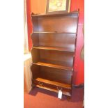 A mahogany waterfall style open bookcase fitted with two base drawers