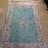 A hand knotted Chinese rug the green ground with floral border