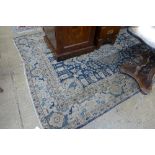 A hand knotted Persian rug the blue ground with floral pendant within multi border