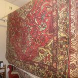 A Persian Hamadan rug with an ivory medallion on a red field surrounded by two borders  206 x 140