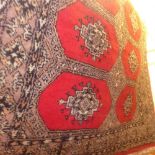 A Persian hand knotted rug the red field with repeating brown motifs