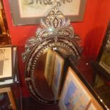 A Venetian style looking glass in a leafy frame with etched detail