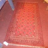 An Afghan rug the dark red field with repeating black motifs in multi border