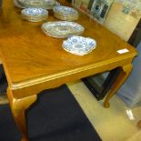 A mid C20th walnut extending dining table raised on cabriole supports