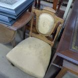 An Edwardian inlaid satinwood nursing chair with gold floral pad back and seat on tapered feet