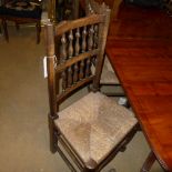 A set of six provincial fruitwood spindle back dining chairs with rush seats on stretchered