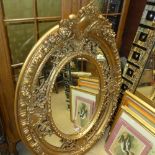A French classical design gilded oval wall mirror with bevelled plate