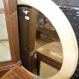 A large oval shagreen wall mirror with bevelled plate