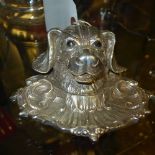 A silver plated inkwell in the form of a