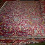 An extremely fine central Persian Varamin rug repeating floral and bird motifs on a rouge field with