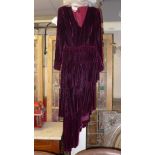 A Burgundy full-length evening dress by Bruce Oldfield, with long sleeves, V-neck and cut-away lower