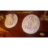 A pair of porcelain wall plaques with cherubs and maidens in relief