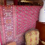 A Bokhara style carpet with many guls on a red field surrounded by one frieze and several running