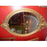 A C19th French wall mirror the oval plate within giltwood frame with beaded detail