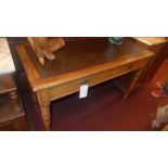 A Victorian oak writing table with lined top above two drawers raised on turned supports and