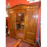 A late C19th mahogany triple wardrobe with central mirrored door flanked by pair of panel doors