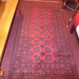 A hand made Afghan rug decorated with guls on a red field surrounded by many borders 192 x 100 cm