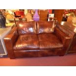 A tan leather upholstered sofa of angular form