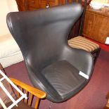 A designer 'Egg' style chair upholstered in black leather on swivel supports