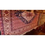 A Caucasian design carpet the dark blue ground with central medallions and repeating motifs in multi