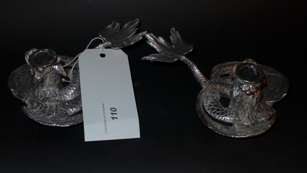 A pair of Japanese white metal chamber sticks in the form of dragons