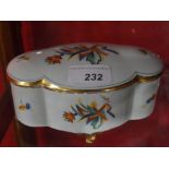 A German Art Deco porcelain box and cover decorated with polychrome geometric motifs raised on