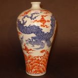 A Chinese vase decorated in blue and orange with intertwining dragons