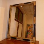 A wall mirror the rectangular plate within ebonised and parcel gilt frame