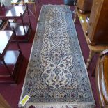 A Persian hand knotted runner the ivory field decorated with pendant medallions and floral motifs