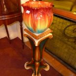 A Bretby jardiniere in brightly coloured glaze and flower head form and a jardiniere stand