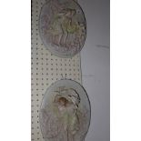 A pair of porcelain wall plaques with cherubs and maidens in relief