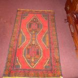 A Persian rug of small size the red ground with central motis