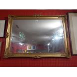A rectangular wall mirror with bevelled plate and in swept giltwood frame together with a glazed and