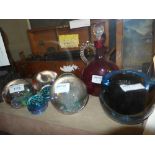 A collection of colour glass paperweight and a cranberry glass decanter
