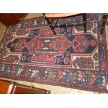 A hand knotted Hamadan rug the red ground with stylized decoration