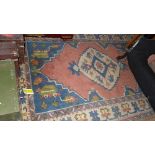 A hand knotted Caucasian rug the pink ground with stylized decoration