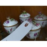 A Meissen set of four porcelain cups and cover with hand painted floral decoration