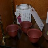 A Chinese porcelain teapot with calligraphy and figural decoration and three terracotta tea bowls