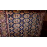 A Persian Bokhara style runner the dark blue ground with repeating gold motifs in a triple border