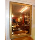 A wall mirror with rectangular plate within carved gilt frame with ribbon detail