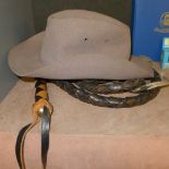 A leather whip with two tone leather handle and a cowboy hat. Whip Length 295 cm