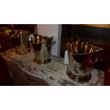 A set of three twin handled oval silver plated wine coolers