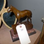A bronzed figure of a horse on a marble base