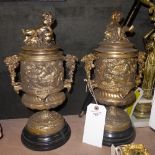 A pair of gilted bronze urns with cherub relief on marble base