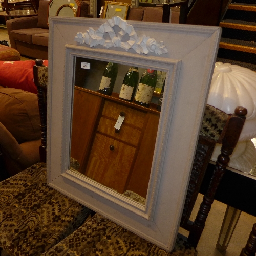 A distressed wall hanging mirror with carved crest