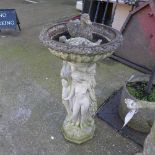 A reconstituted stone birdbath with nude maiden support